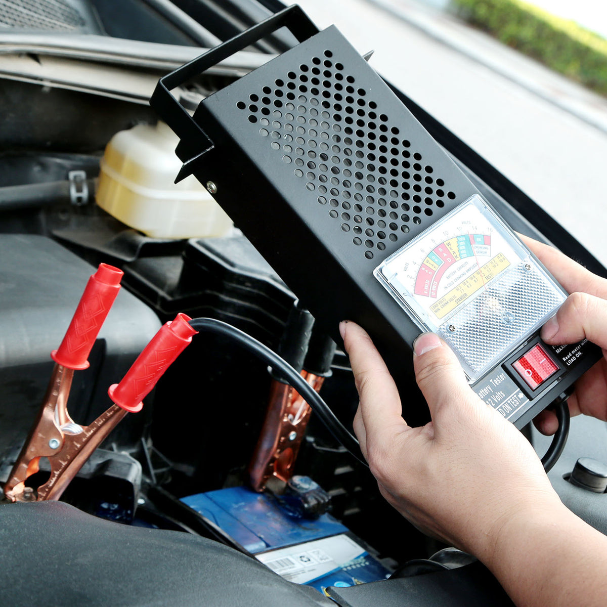 BatteryLoad 12 tester in use on a vehicle battery under the hood