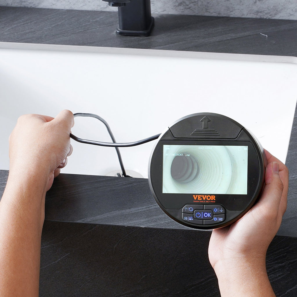 VEVOR triple-lens borescope round retractable case held in two hands during an inspection